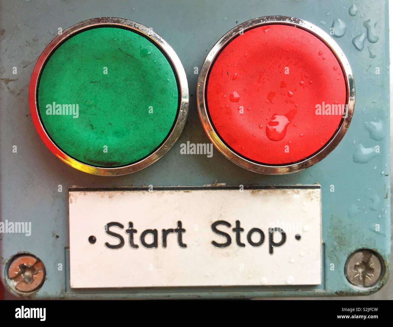 A red and a green button with a sign saying stop or start in a decision-making image about choice - Smartphone Captured Stock Image