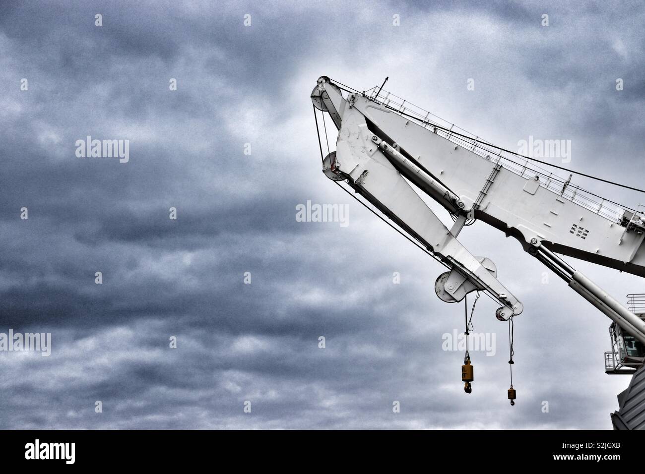 Ships crane set against grey skies Stock Photo