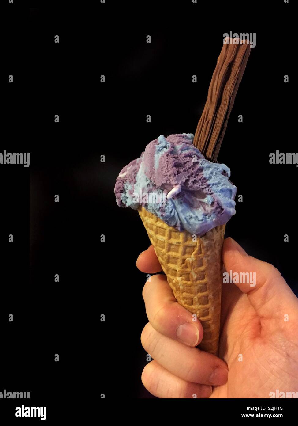 Ice cream cone with chocolate flake.  Summer sweet treat for the beach.  Holiday time.  Background black for caption or editing. - Smartphone Captured Stock Image Ice cream cone with chocolate flake.  Summer sweet treat for the beach.  Holiday time.  Background black for caption or editing. - Smartphone Captured Stock Image