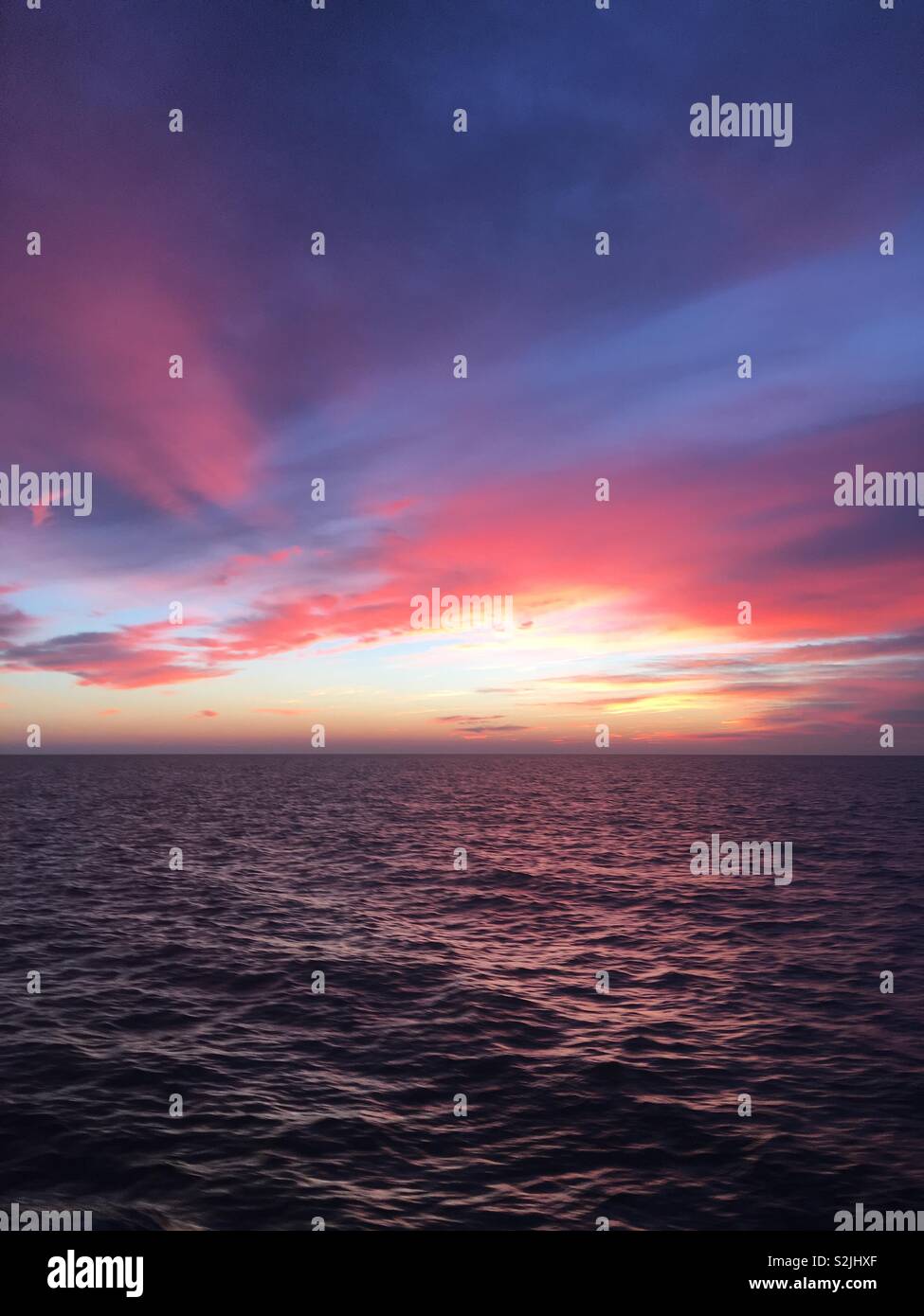 A  colourful sunset reflected on the sea - Smartphone Captured Stock Image