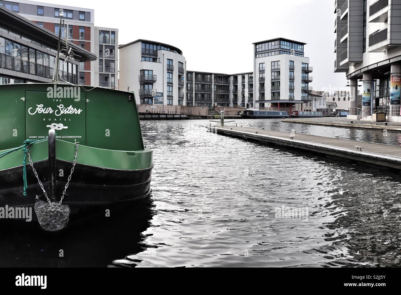 Canal barge moored at Edinburgh Quay with surrounding architecture Stock Photo