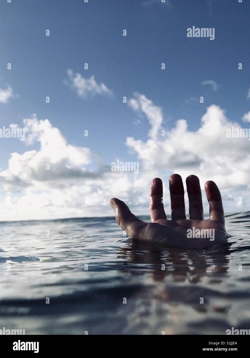 A hand floating in water. Hanalei Bay, Kauai, USA. - Smartphone Captured Stock Image