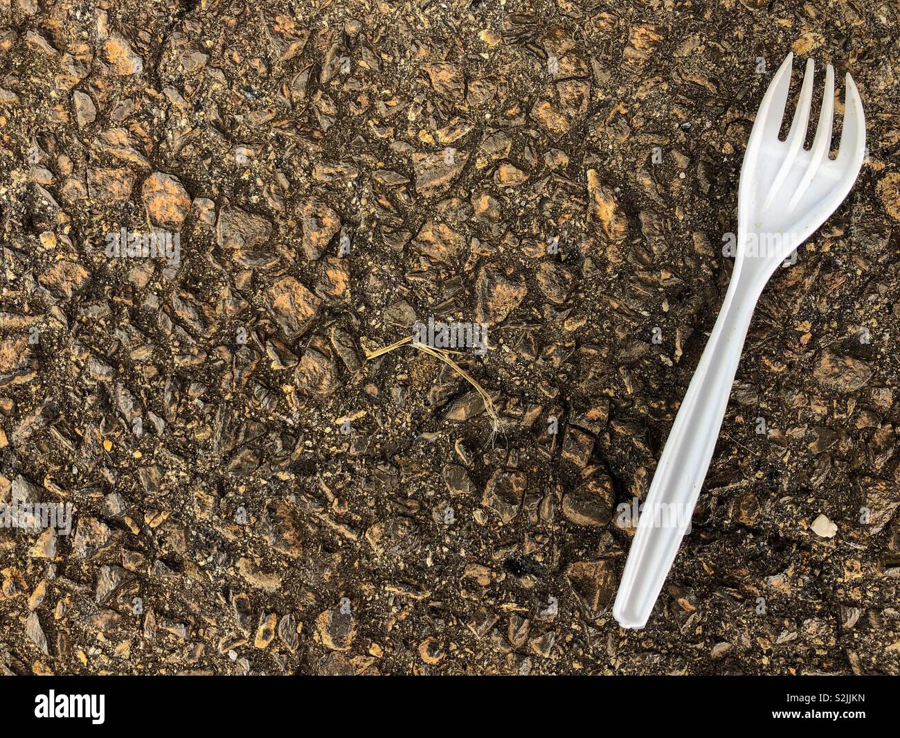 Plastic fork on the ground. Stock Photo