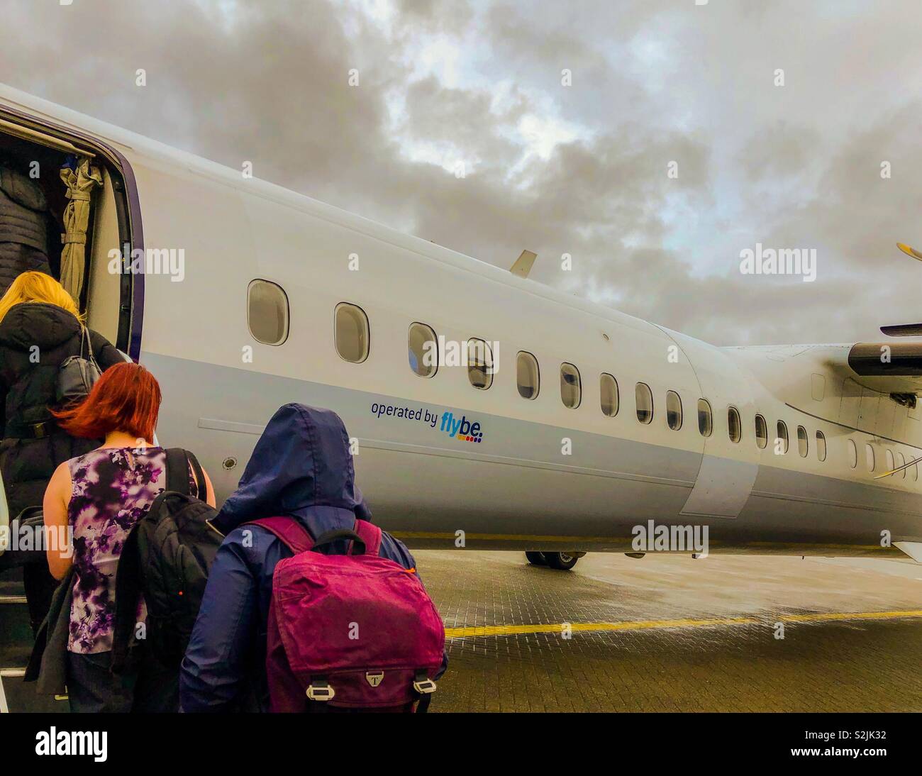 Passengers boarding aircraft at wet and windy Birmingham airport. UK. - Smartphone Captured Stock Image