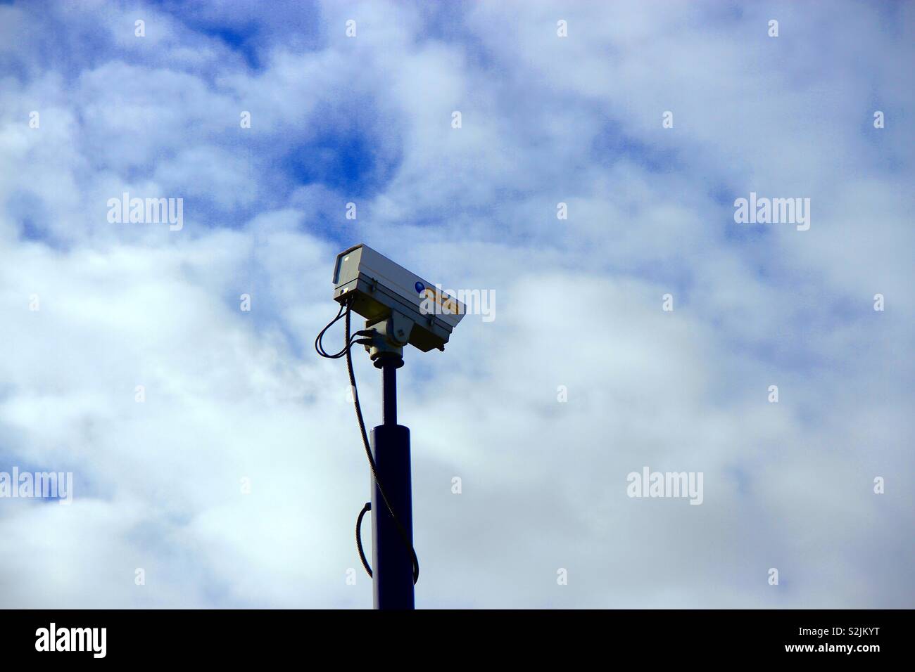 CCTV camera against white cloud and blue sky Stock Photo