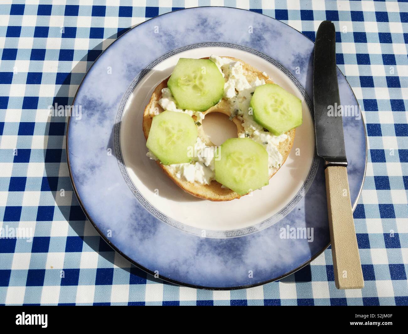 Bagel With Cottage Cheese And Cucumber Topping Stock Photo