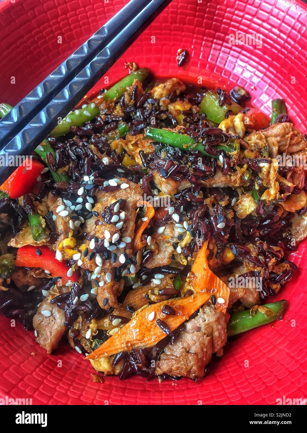 Fried red rice with beef and vegetables, wok chinese food close up - Smartphone Captured Stock Image