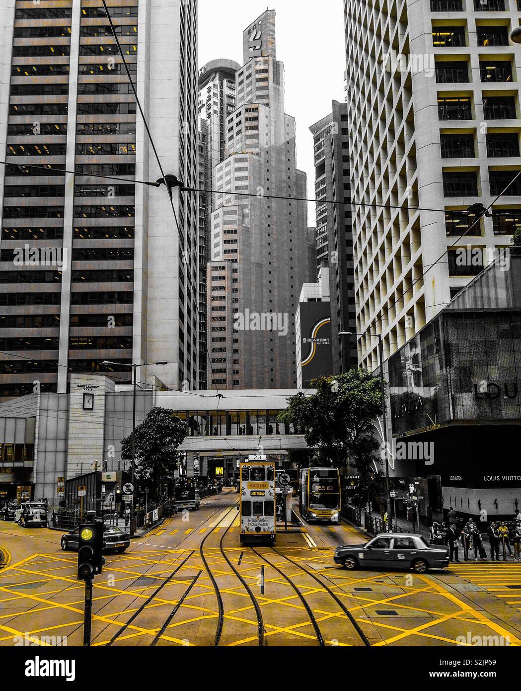 View of tram and yellow checkered junction on Hennessy road, Hong Kong island. Split tone image. Stock Photo