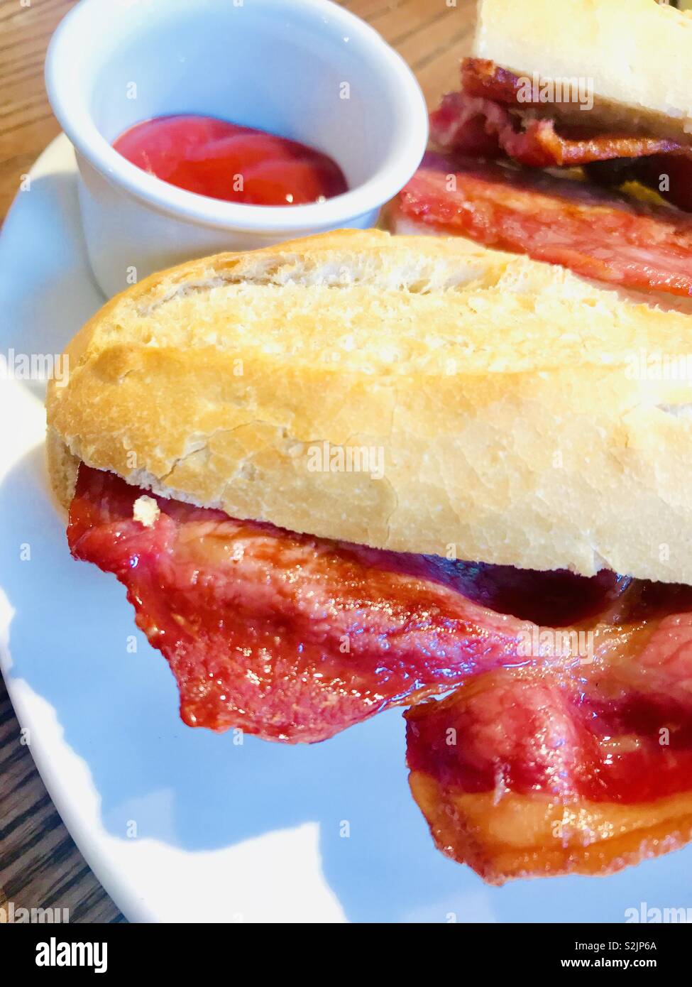 Bacon sandwich served on a white baguette with tomato ketchup Stock