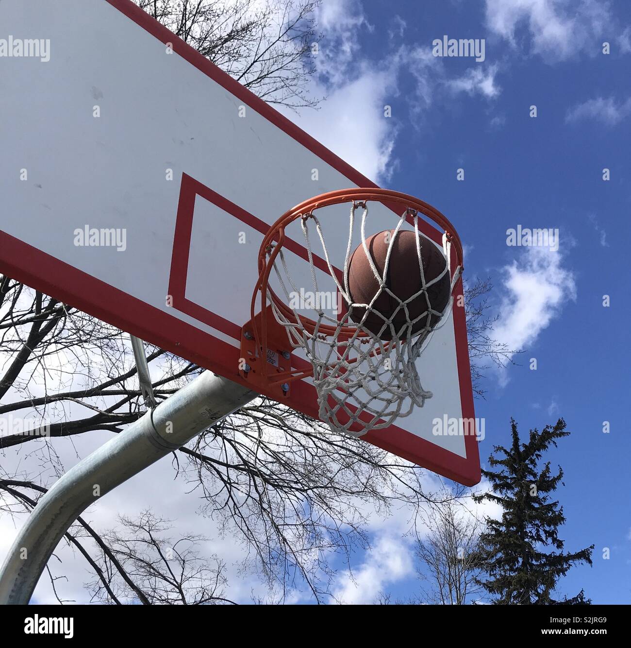 Basketball swishes through the net at the playground Stock Photo Alamy