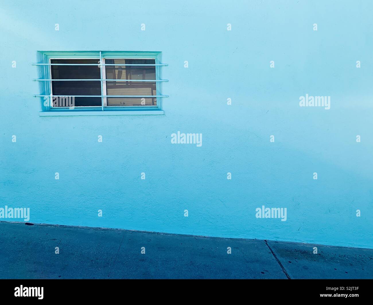 Blue wall with a window with bars on it. Manhattan Beach, California USA. - Smartphone Captured Stock Image