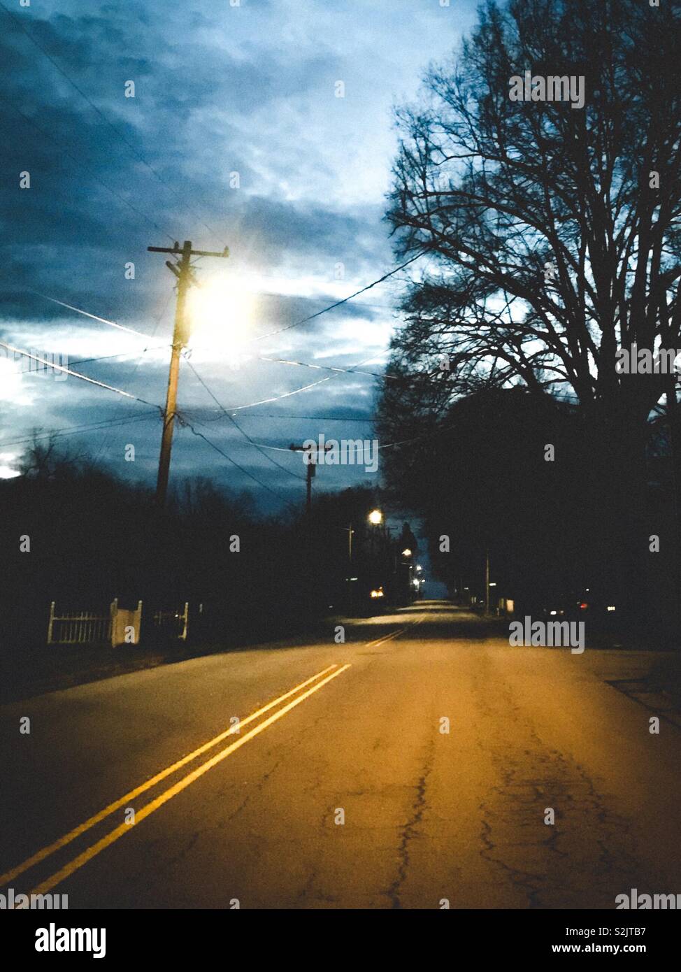 Dark before dawn on deserted street with trees in silhouette - Smartphone Captured Stock Image