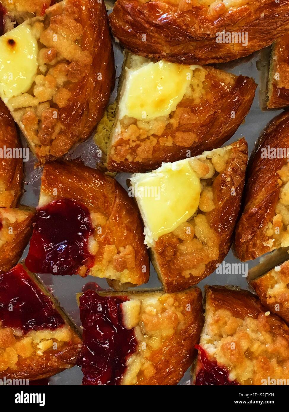 Delicious fresh cheese and raspberry danish desserts cut into quarters and served on a plate. - Smartphone Captured Stock Image