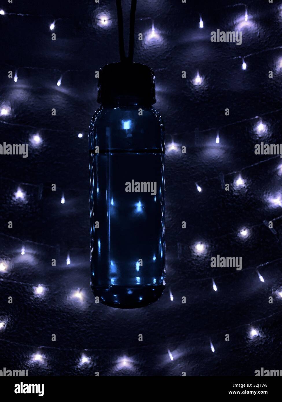 Background. Abstract and cold. A bottle of water in a space full of decorative lighting Stock Photo