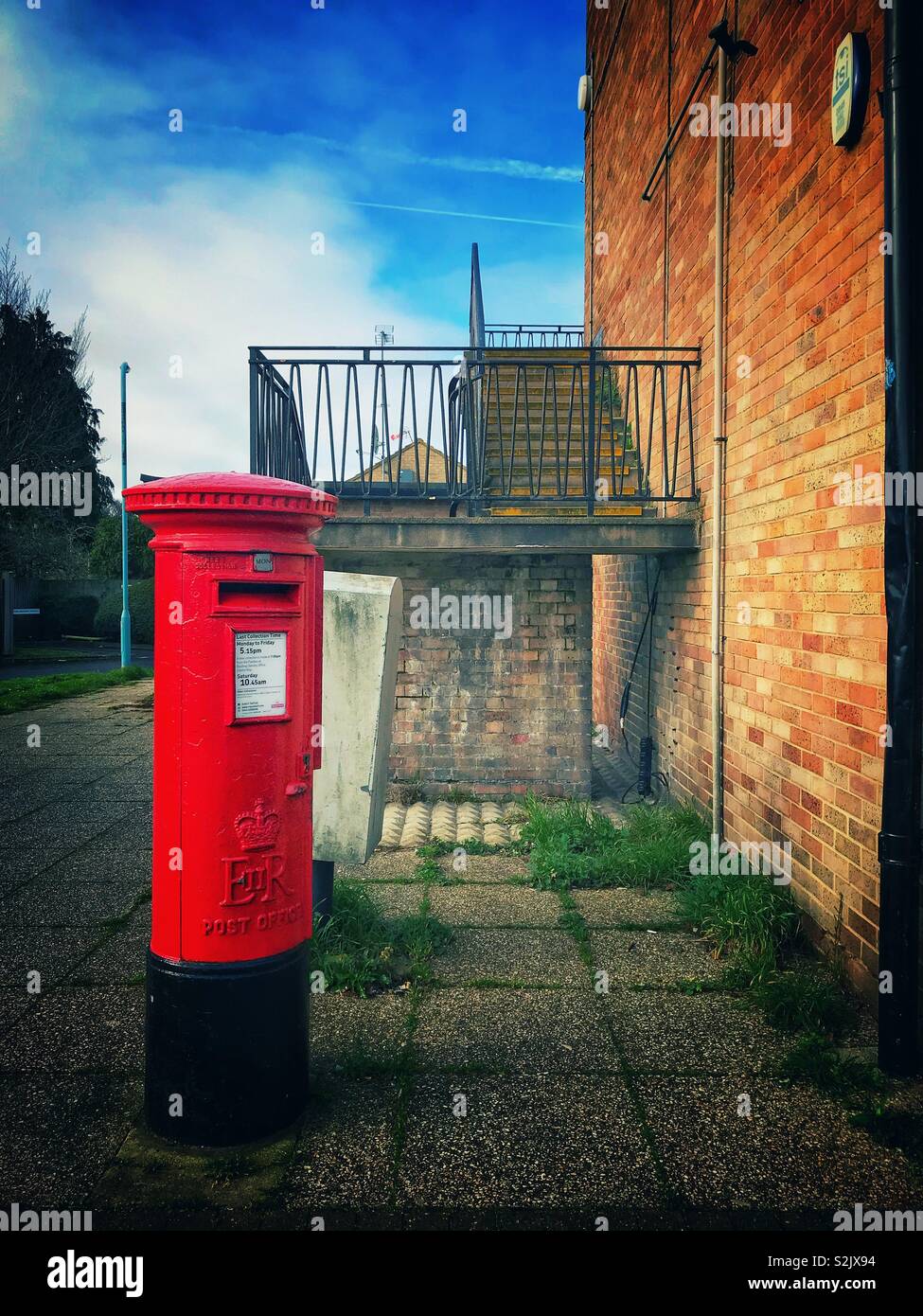Red postbox in front of steps. - Smartphone Captured Stock Image