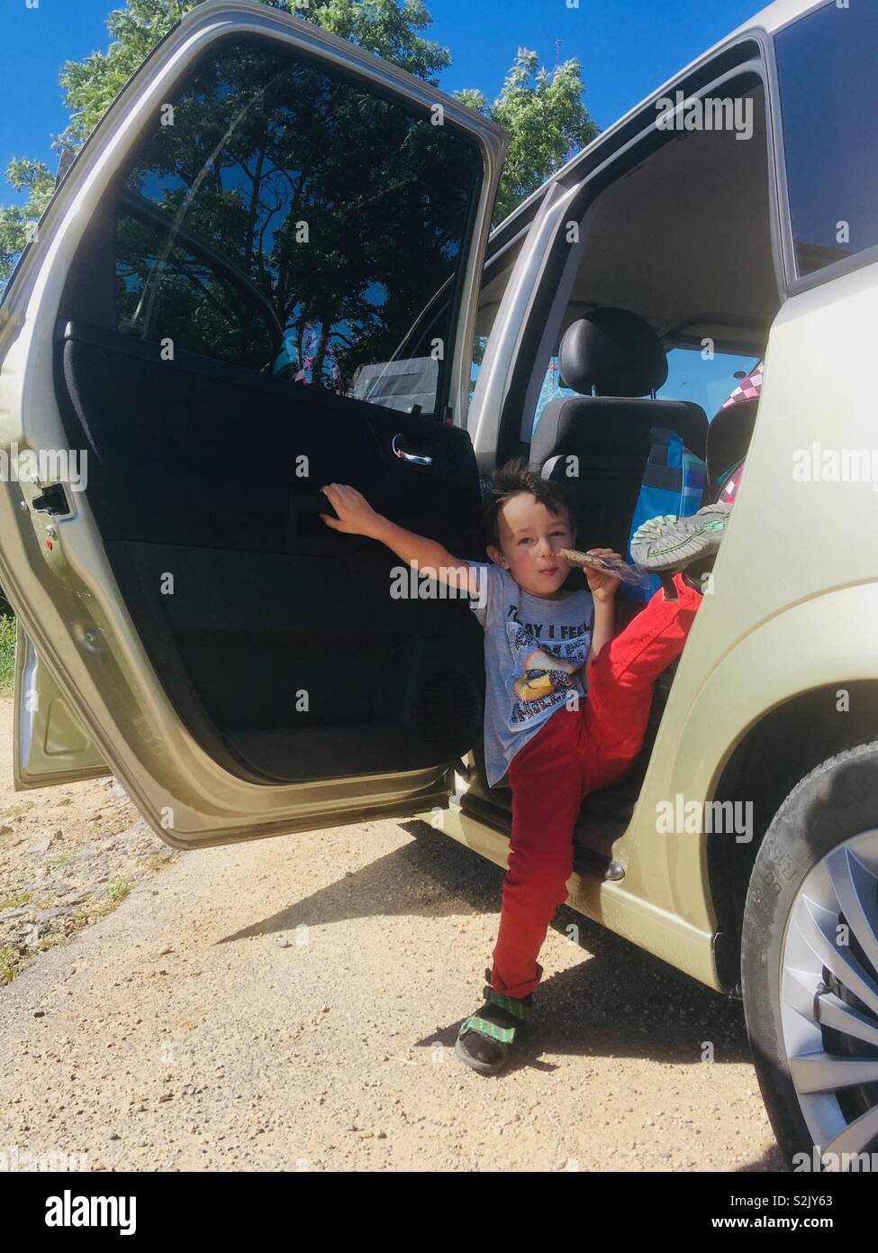 Child eating in car, door open - Smartphone Captured Stock Image