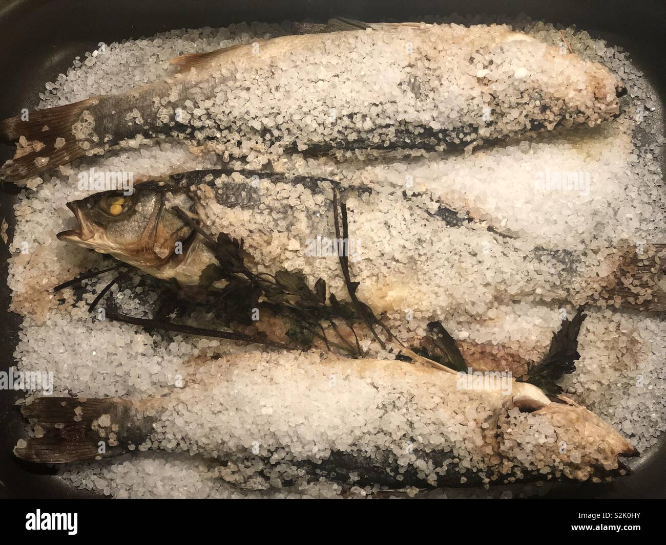 Baked sea bass under salt Stock Photo Alamy