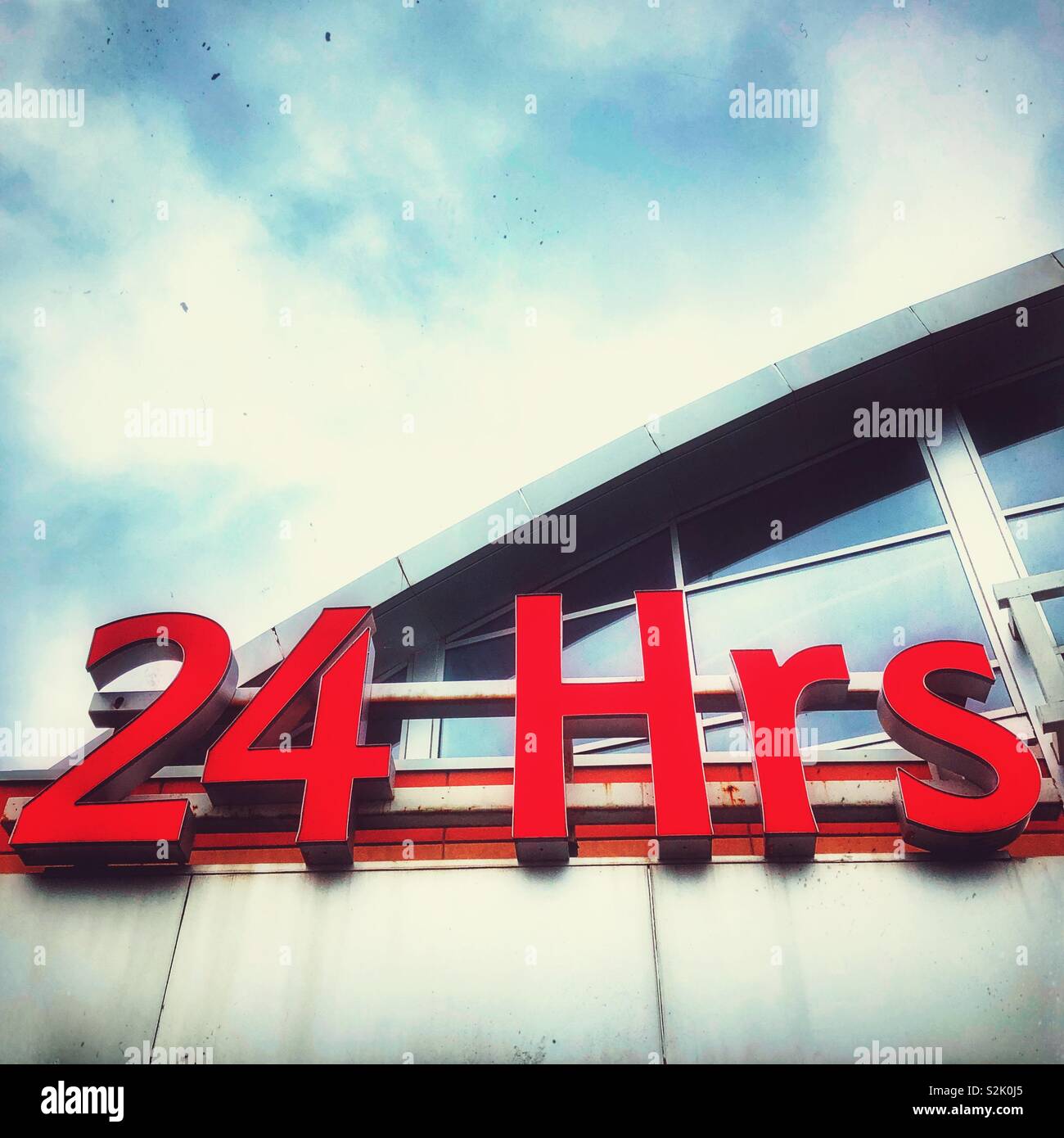 24 Hrs sign on the top of a grocery store Stock Photo