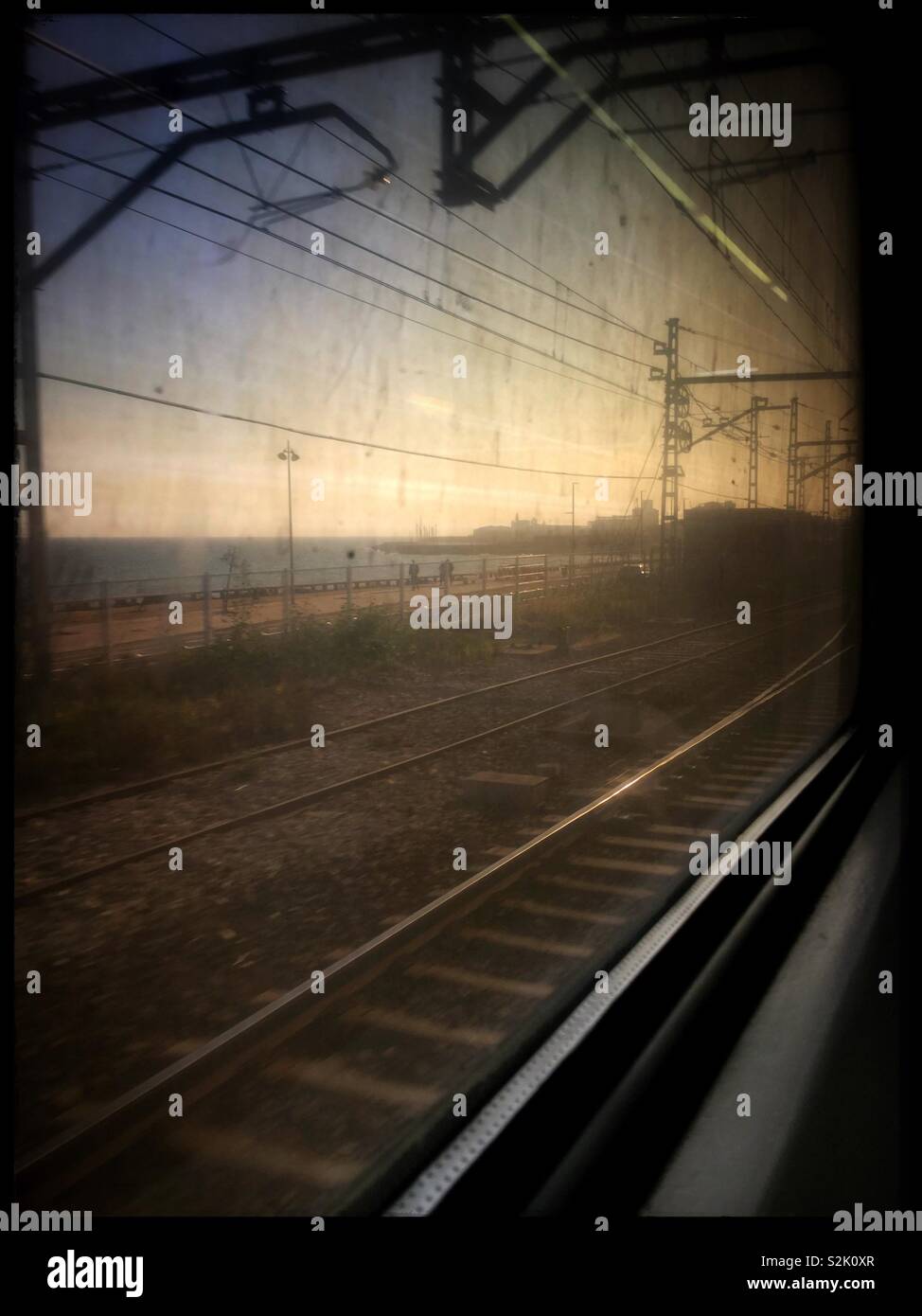View of the Mediterranean Sea through a dirty train window on the Catalunya Express, Catalonia, Spain. - Smartphone Captured Stock Image