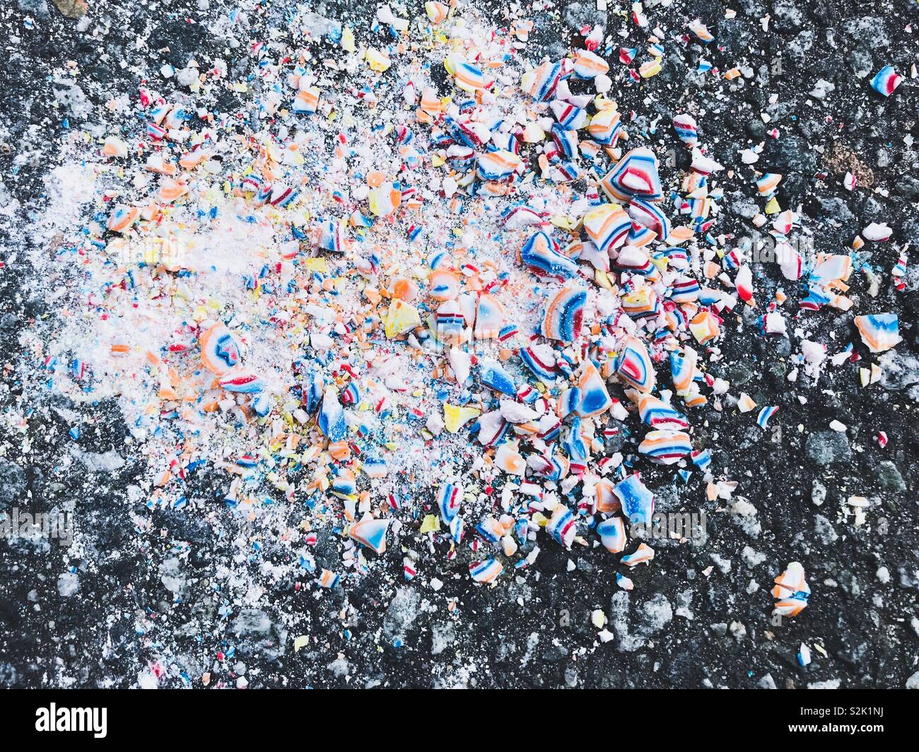 Bright, colorful crushed candy on pavement Stock Photo
