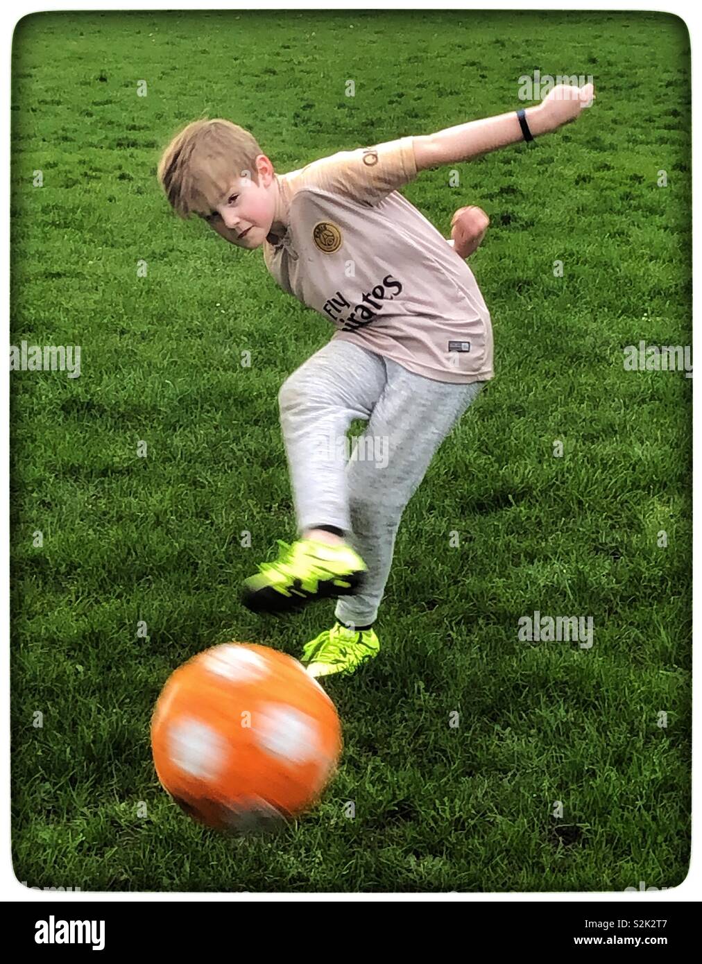 Boy kicking a football Stock Photo