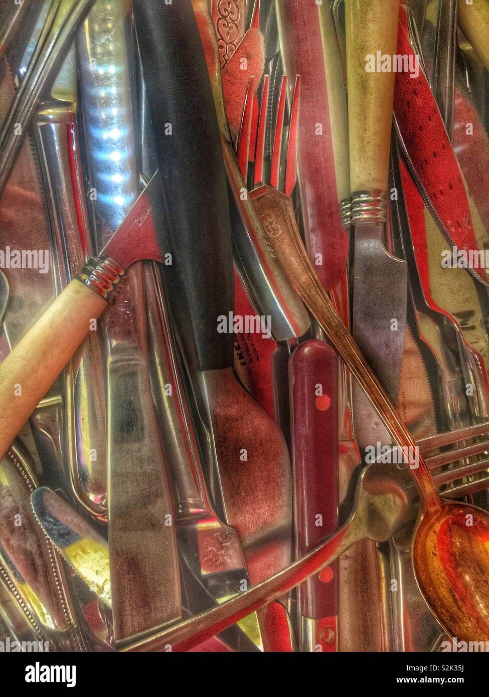 Junk drawer full of old mismatched forks, knives, and spoons. - Smartphone Captured Stock Image