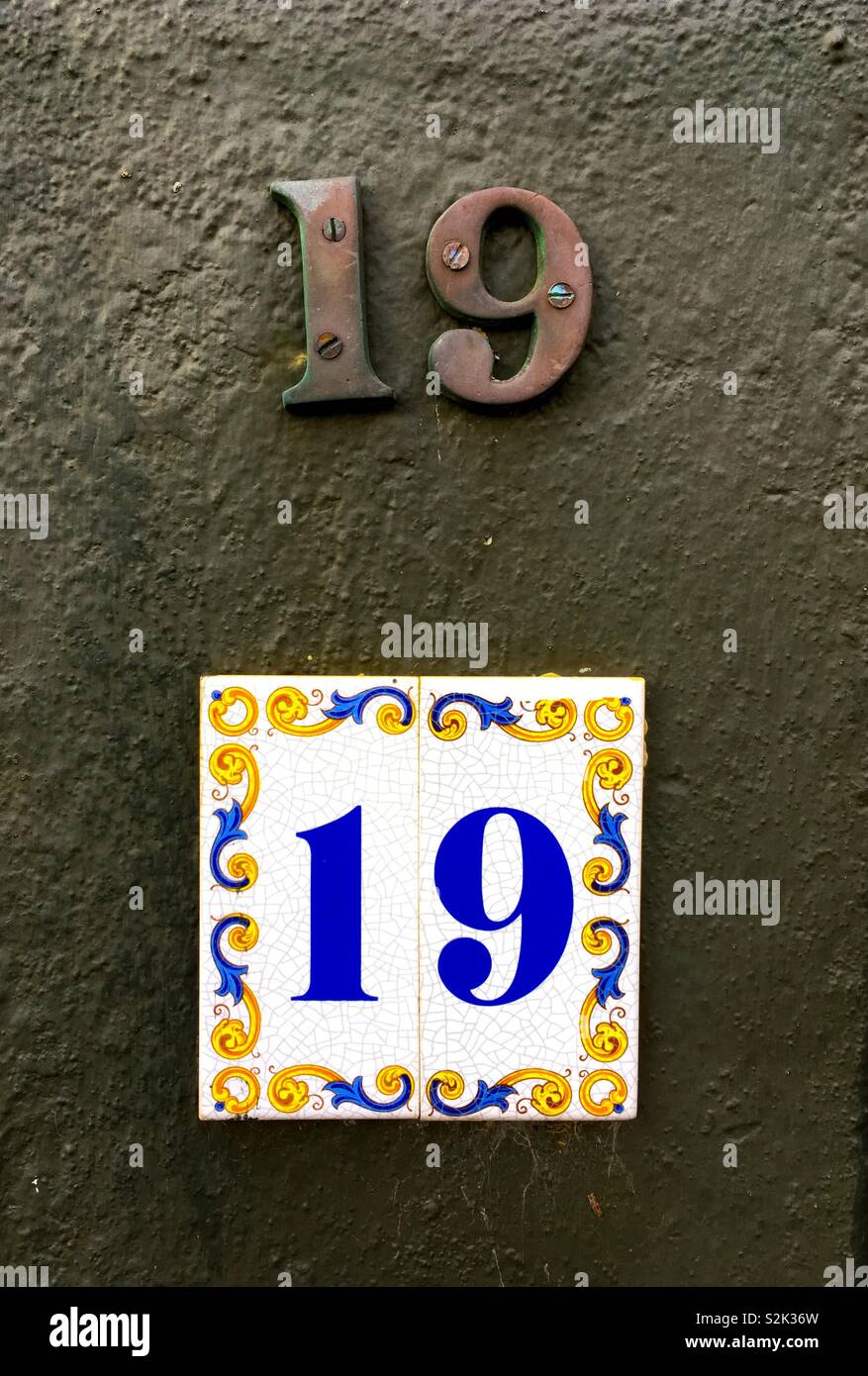 Number 19 in metal numerals and on a ceramic tile for the same house. Stock Photo