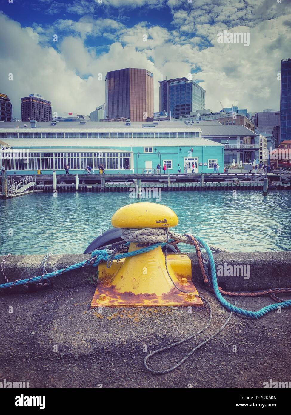 Yellow bollard on a dock in the city Stock Photo