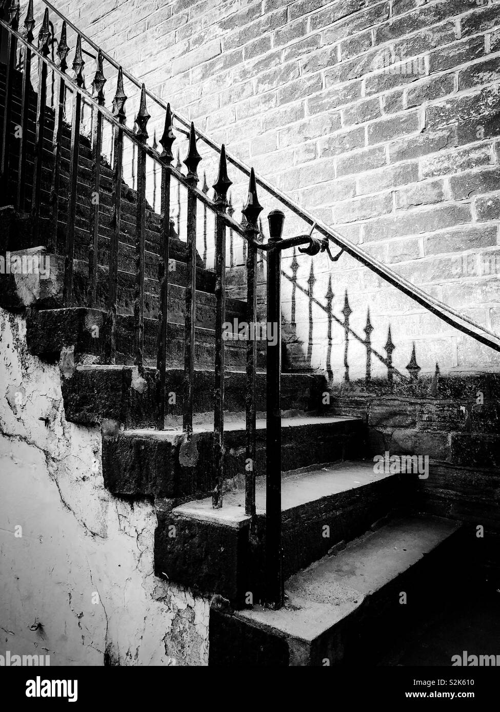 Black and white image of old, stone steps with wrought iron railings - Smartphone Captured Stock Image