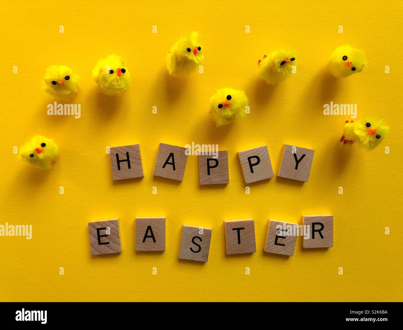 Happy Easter message with fluffy chicks on bright yellow background Stock Photo