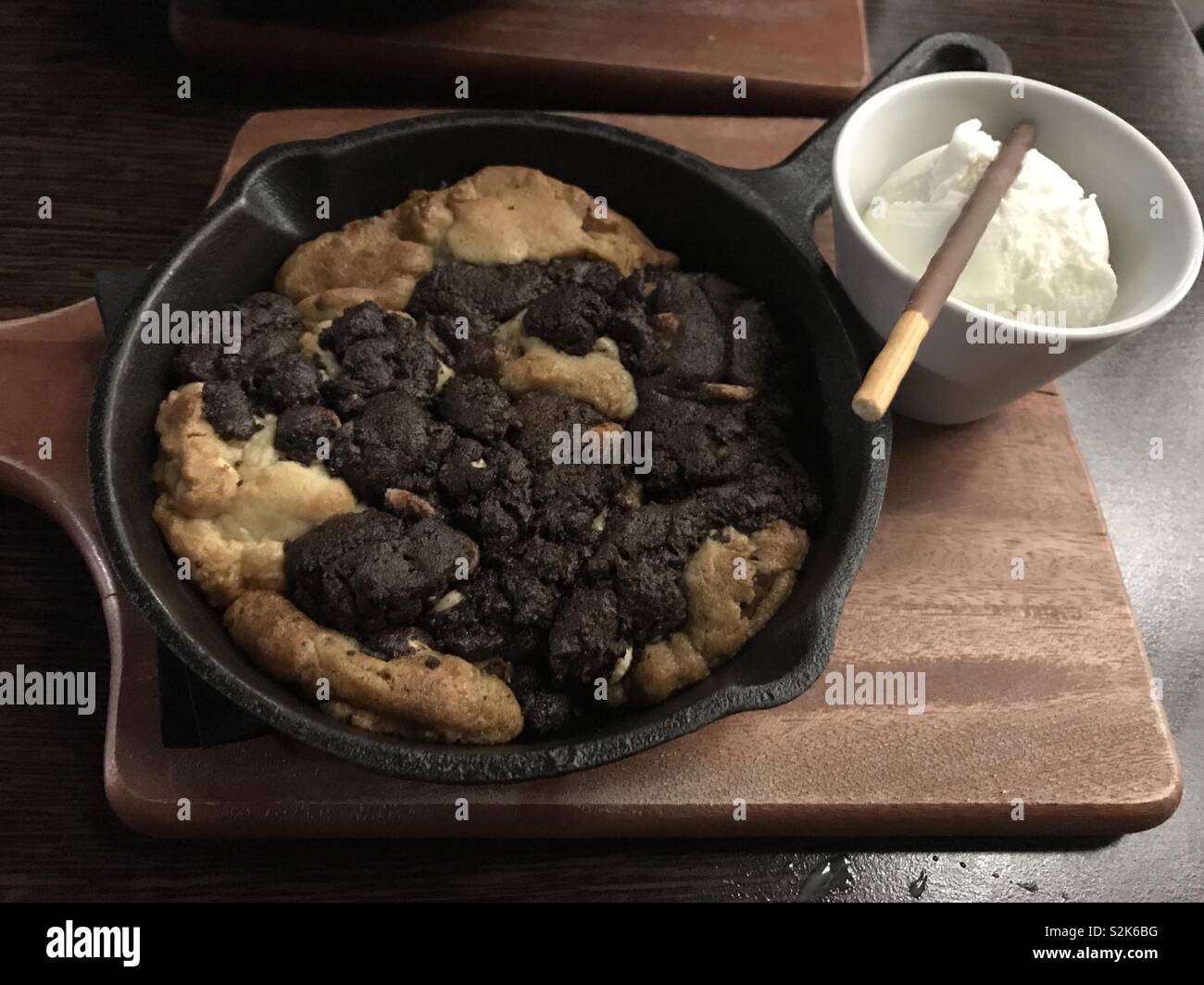 Mixed Double chocolate and Chocolate chip cookie dough dessert in skillet pan with vanilla ice cream Stock Photo