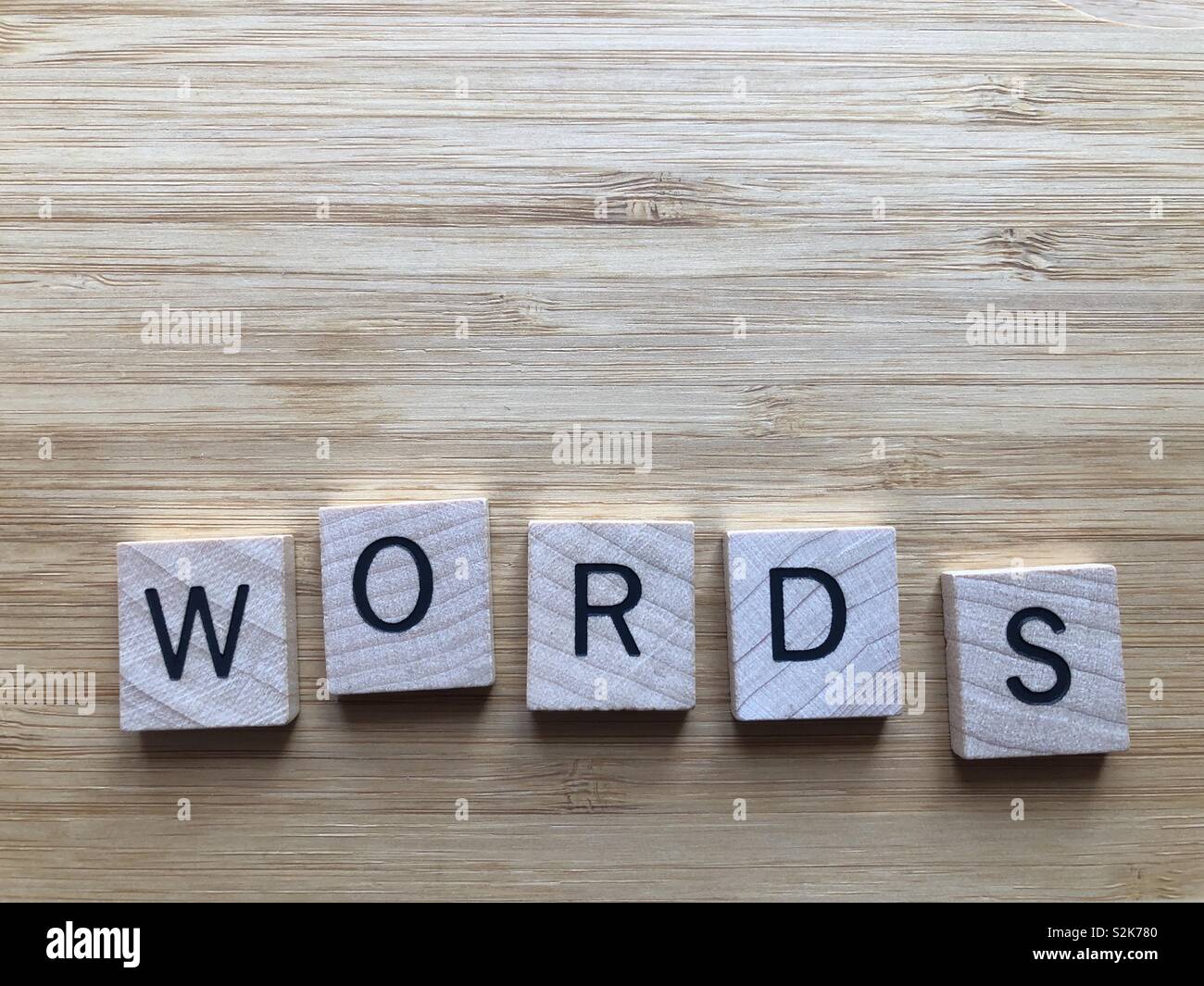 Words, in wooden letters isolated on a bamboo board background with copy space - Smartphone Captured Stock Image