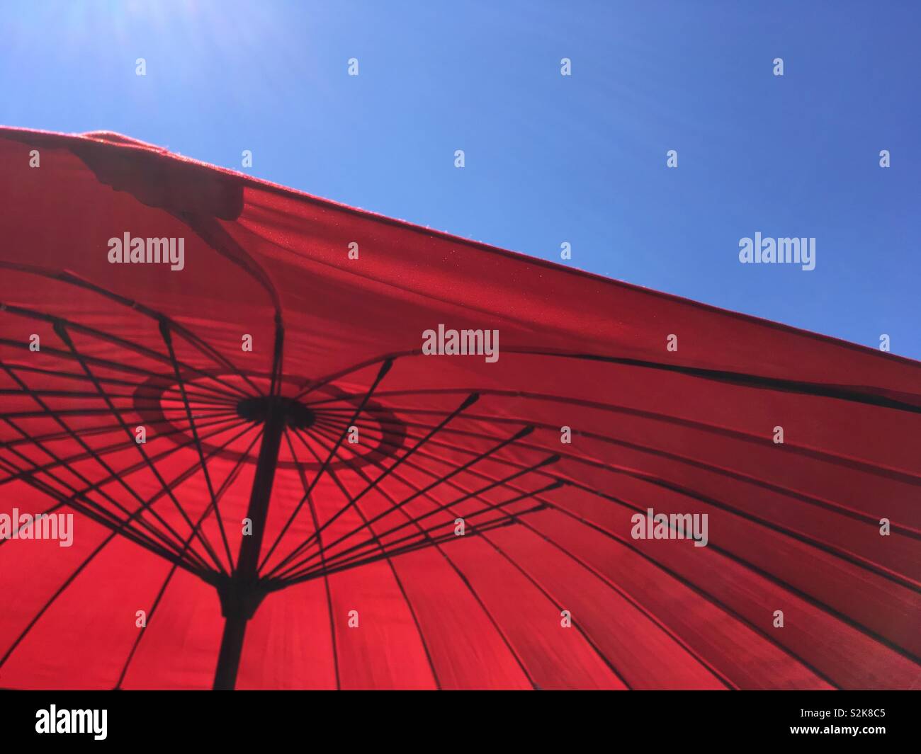 A red umbrella against a blue sky Stock Photo