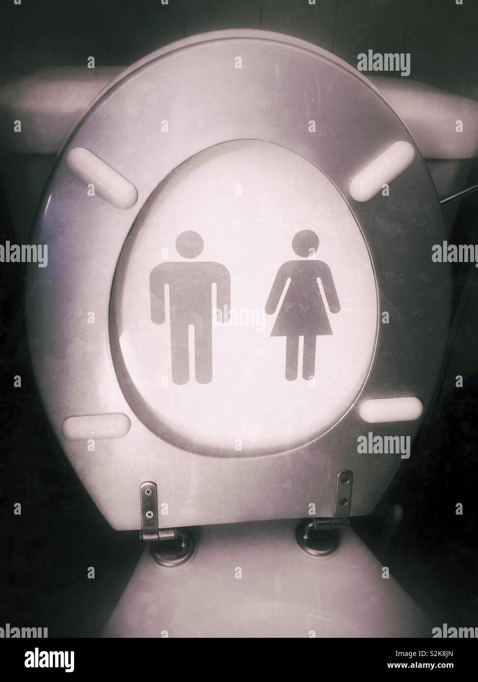 Toilet seat with both male and female symbols. Gender-neutral toilets promote inclusivity and ensuring everyone feels comfortable and safe - Smartphone Captured Stock Image