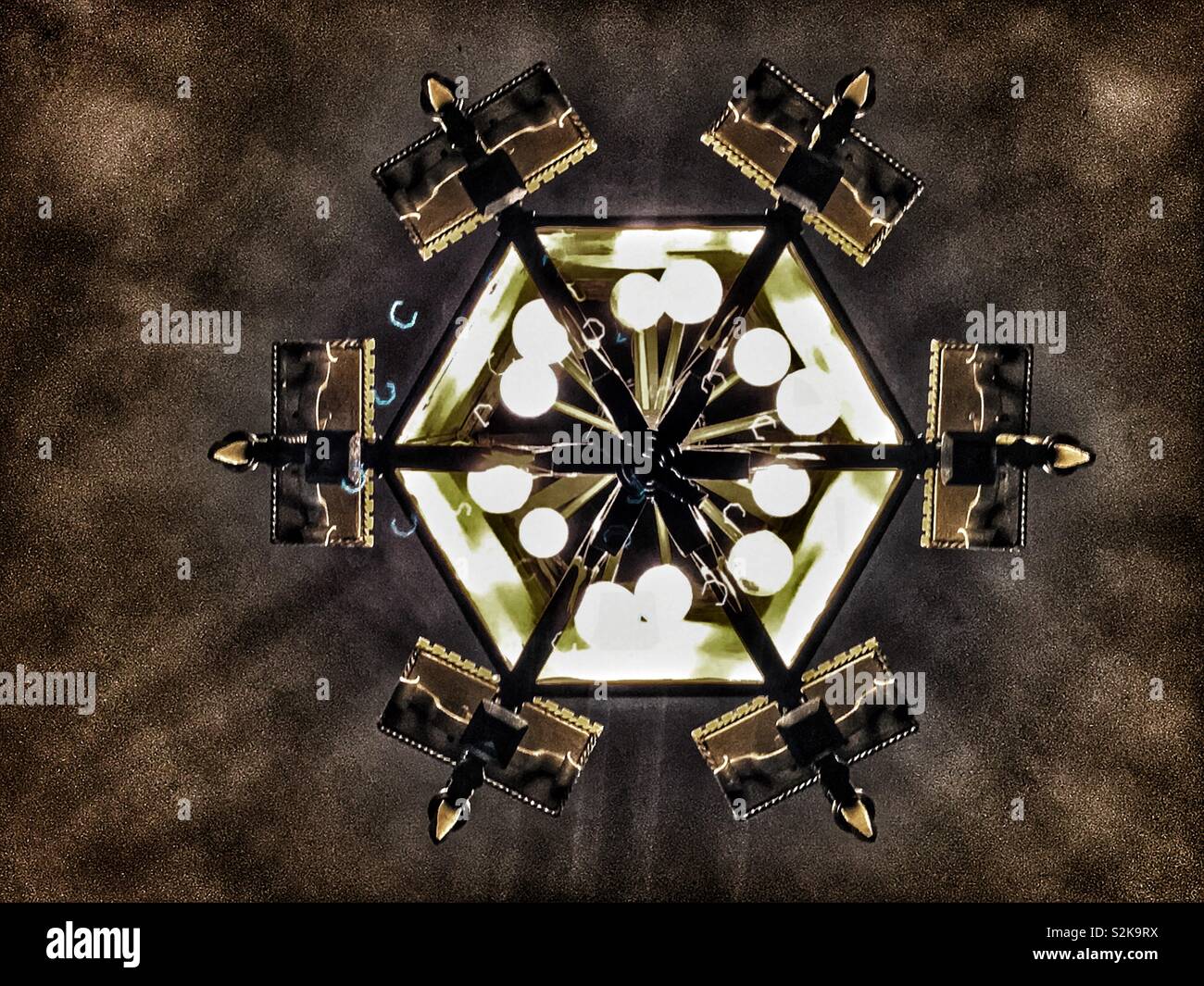 Bottom view of an antique vintage and authentic lit and very elaborate and dramatic medieval chandelier. - Smartphone Captured Stock Image