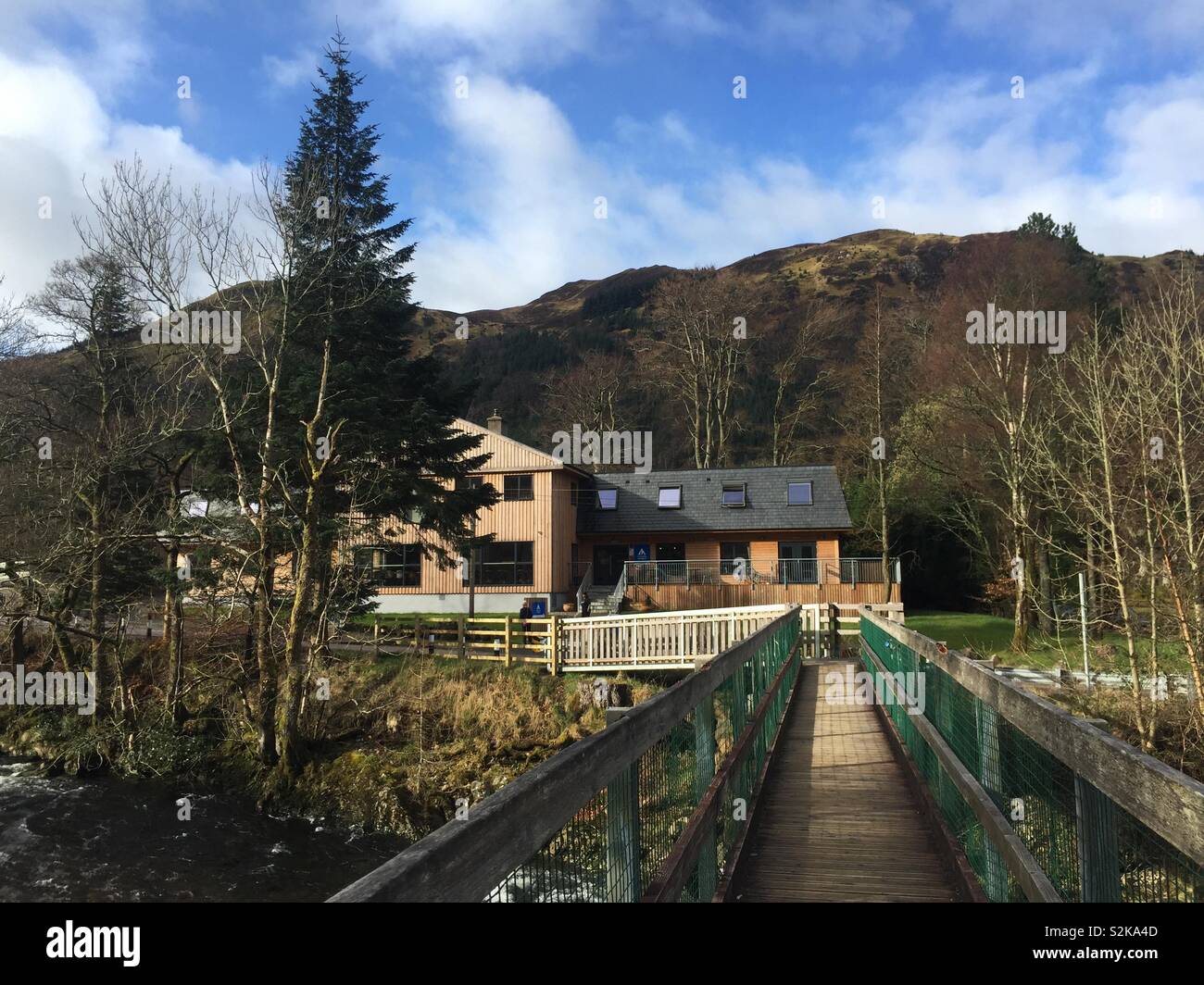 Youth Hostel accommodation building with mountain landscape and bridge, Glen Nevis, Fort William, Scotland Stock Photo