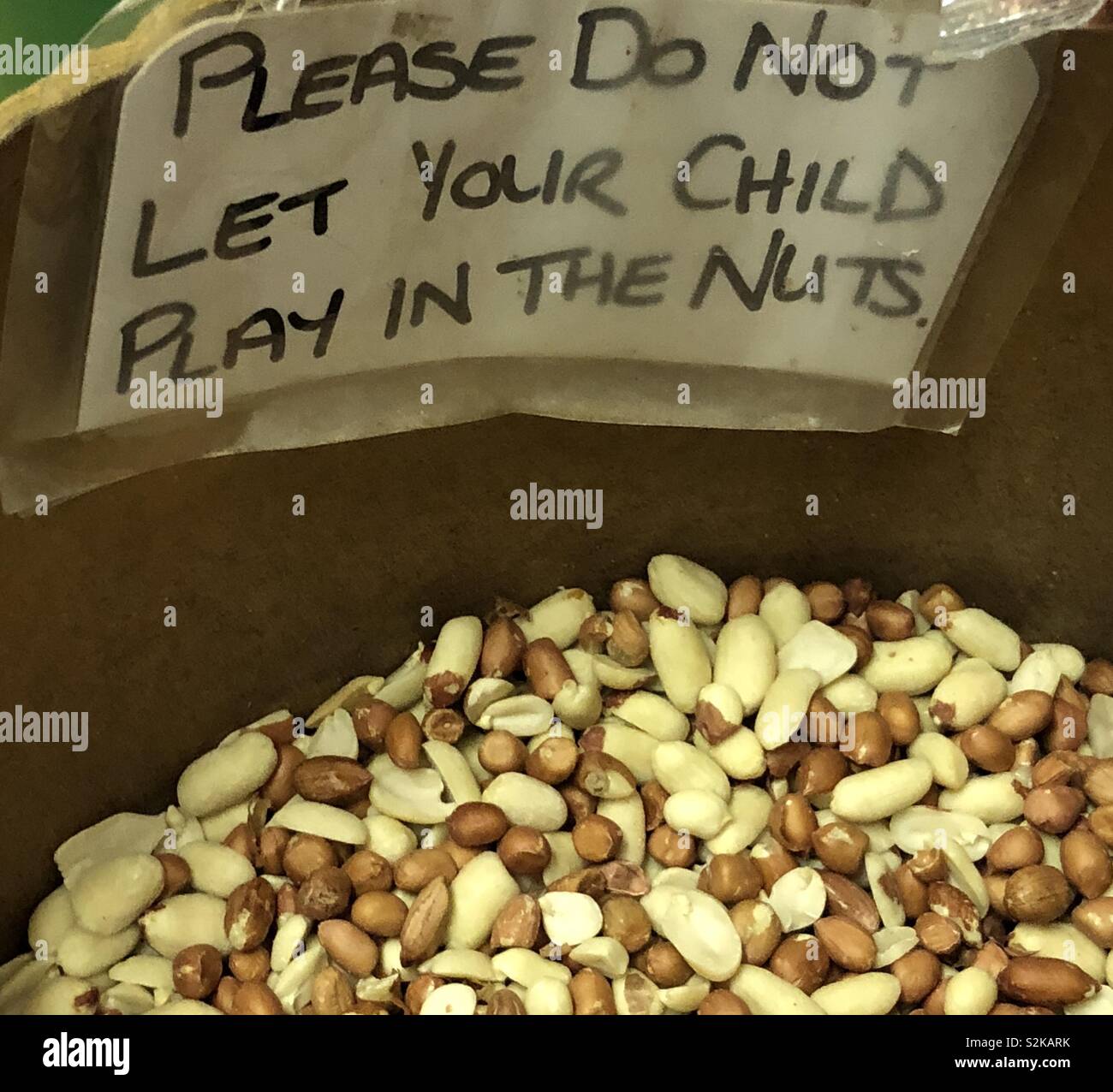 Hand written sign in a grocery shop displayed on an open container of nuts - Smartphone Captured Stock Image
