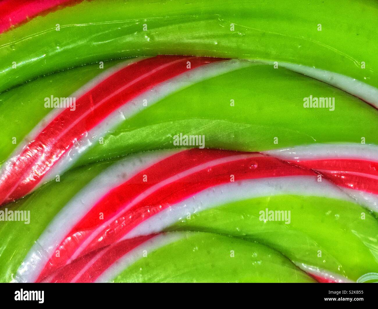 Full frame of a delicious fresh green, red and white swirled hard candy lollipop. - Smartphone Captured Stock Image