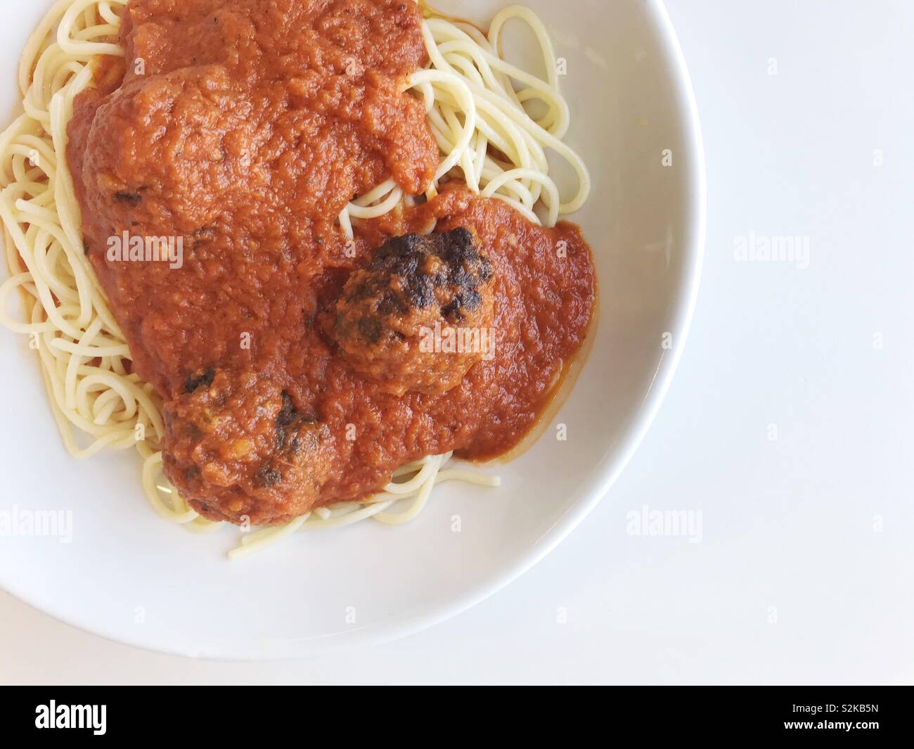 Spaghetti with meatballs and tomato sauce in a white bowl. - Smartphone Captured Stock Image