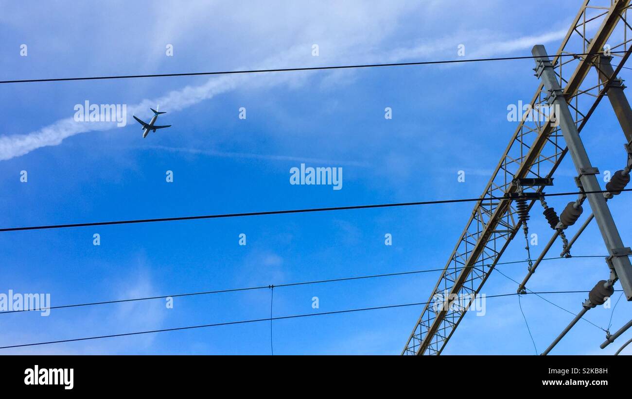 Blue sky and plane flying off on holiday.  Aircraft in the summer skyline jetting off for vacation.  Aviation insurance and fuel flights. Stock Photo
