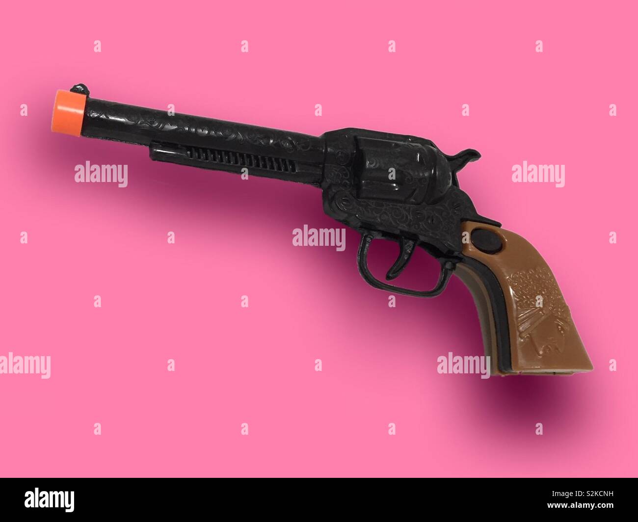 Plastic toy gun on bright pink background.  Guns and gun law.  Firearms banned and licensing in the US.  Games and protection.  A toy gun Stock Photo