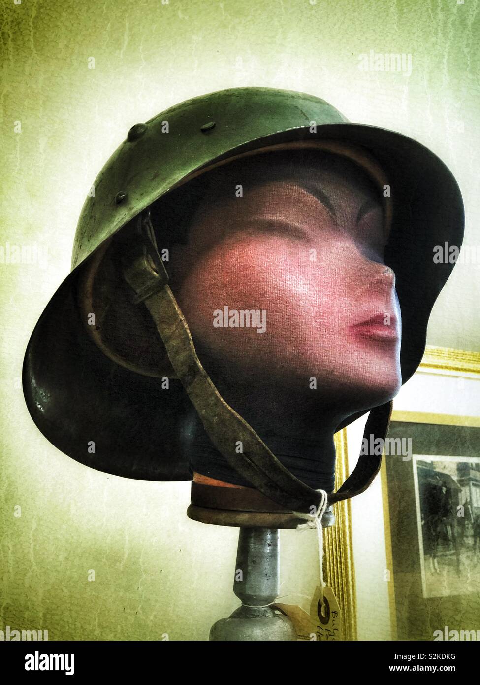 Antique military helmet displayed on a female mannequin head in an antique shop Stock Photo