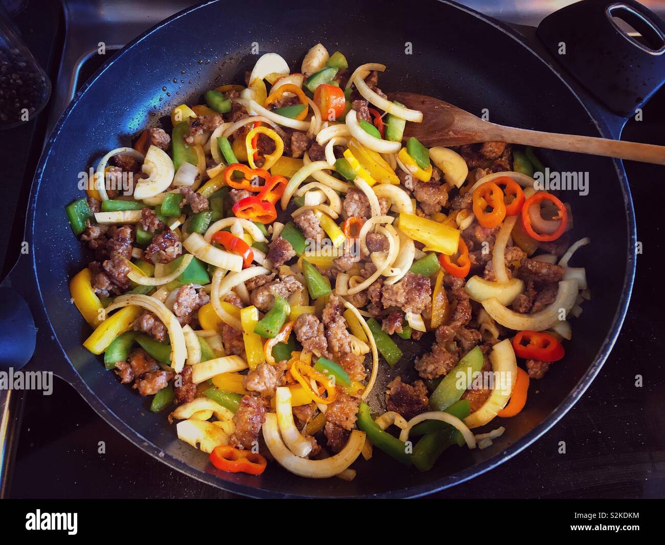 Hot Italian sausage being sautéed in a pan with onions and peppers - Smartphone Captured Stock Image