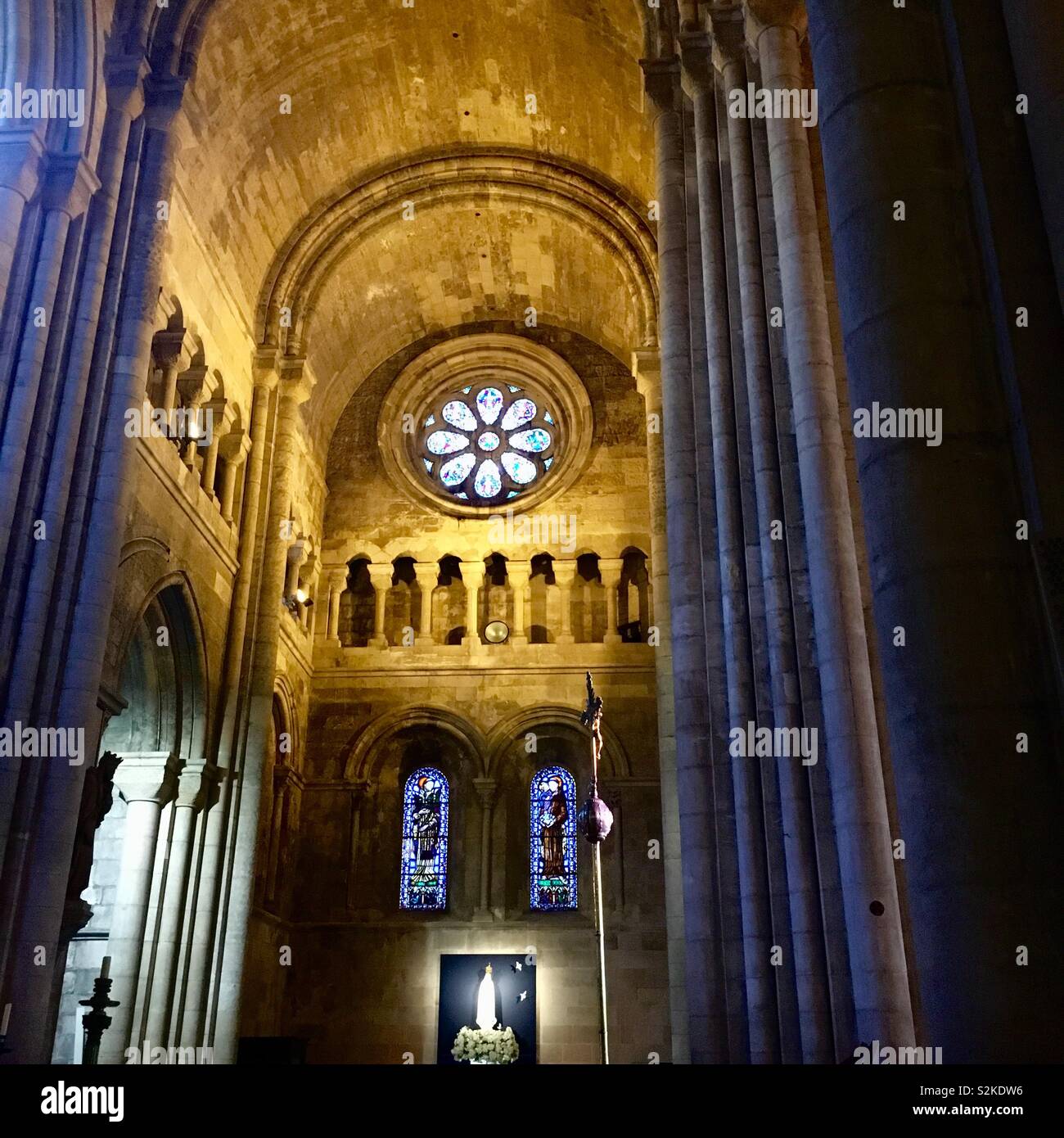 Lisbon cathedral - the cross and stain glass windows against the high ceiling Stock Photo