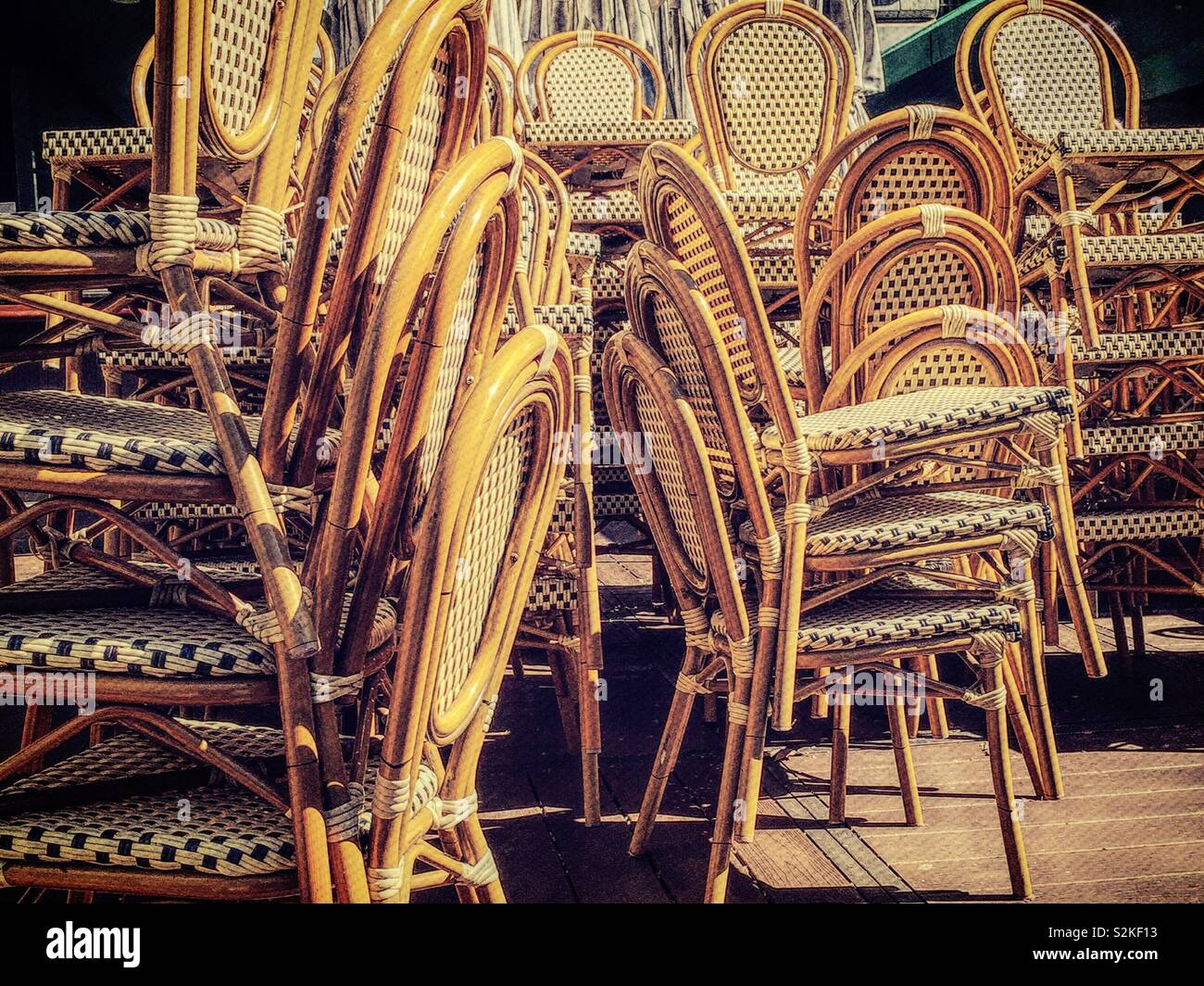 Stacks of wood and wicker chairs awaiting the opening of an outdoor café in Bryant Park, NYC, USA - Smartphone Captured Stock Image