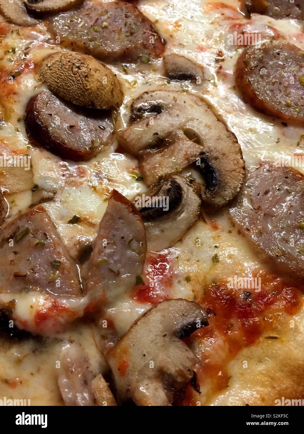 Close up of a hot slice of sausage and mushroom pizza, NYC, USA - Smartphone Captured Stock Image