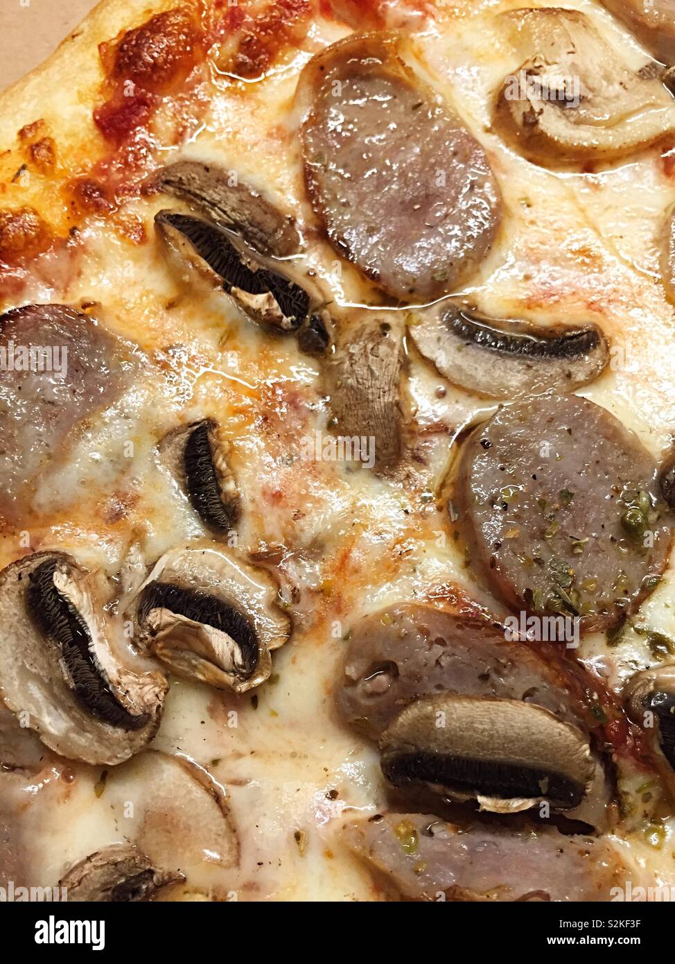 Close up of a hot slice of mushroom and sausage pizza, NYC, USA - Smartphone Captured Stock Image