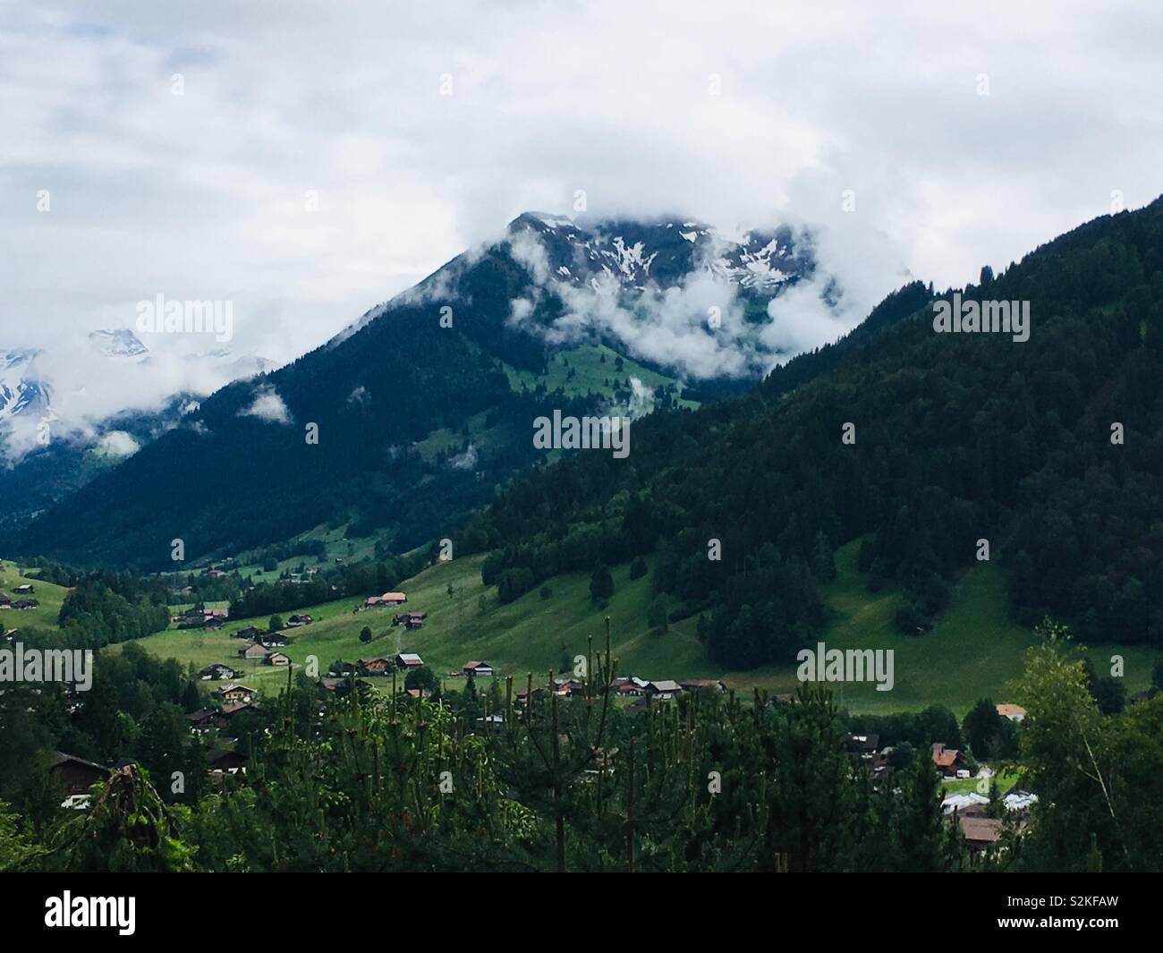 Landscape of mountains and cottages; Gstaad; Switzerland Stock Photo