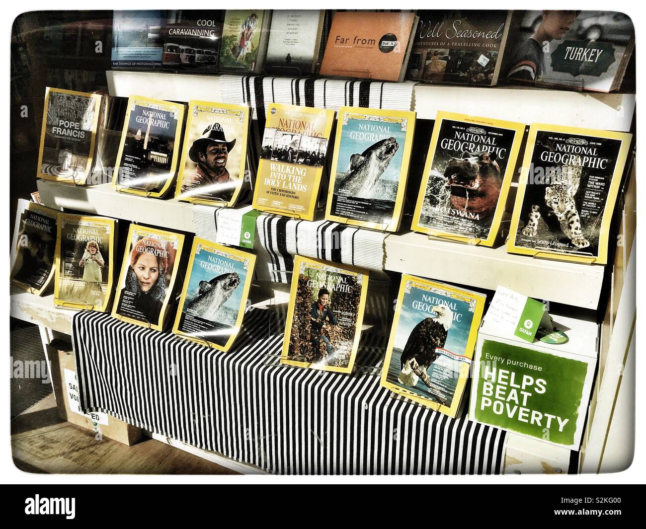Oxfam book shop window displaying National Geographic magazines - Smartphone Captured Stock Image