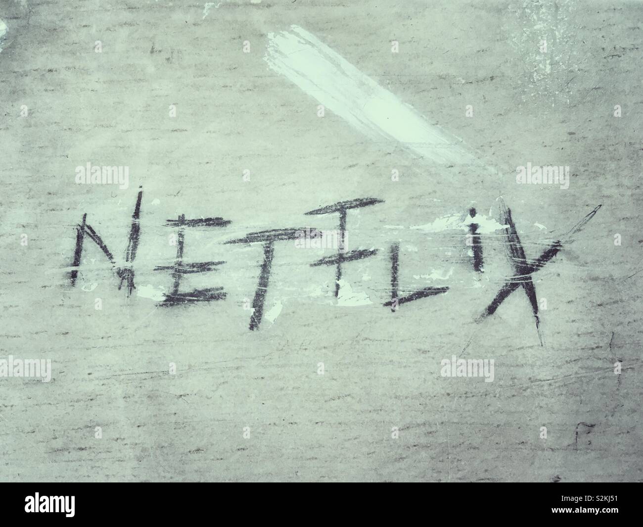 Netflix written with a pencil on a wooden surface - Smartphone Captured Stock Image